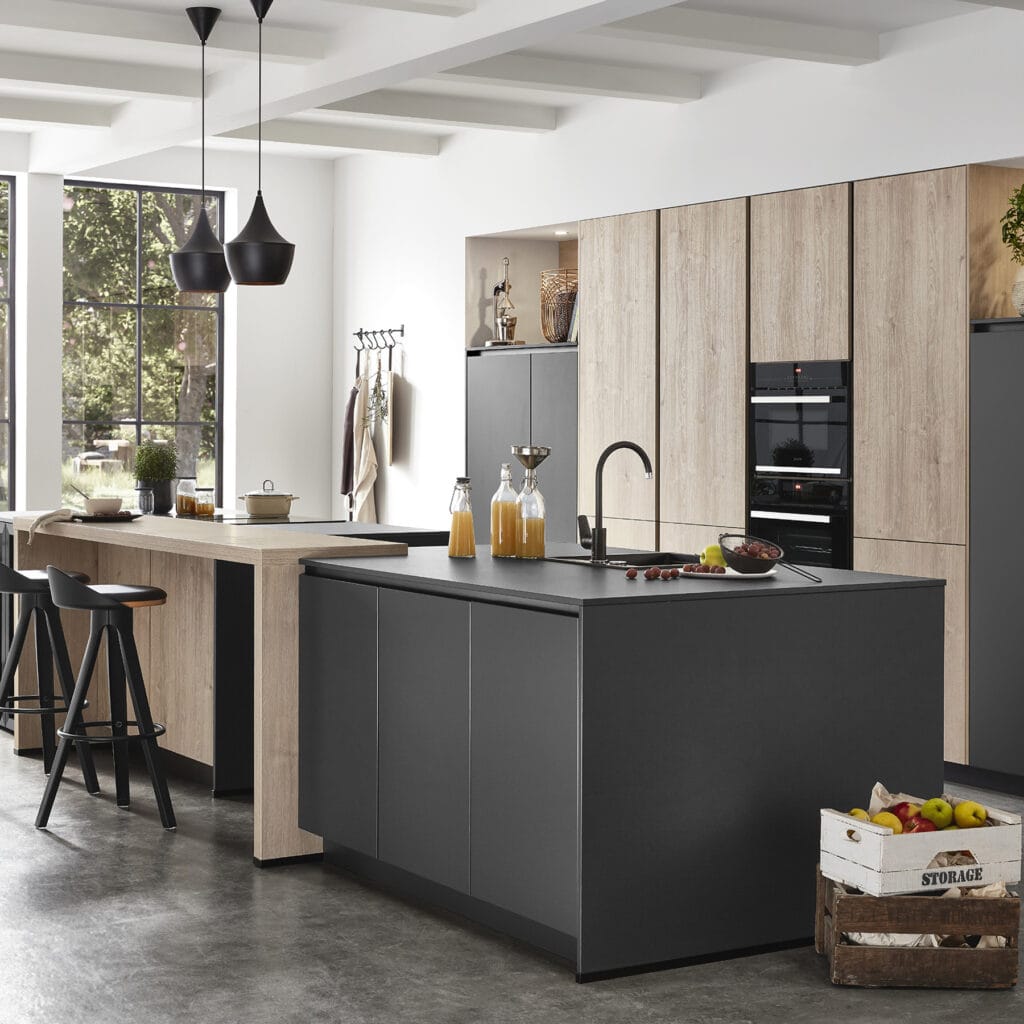 Cocina con isla central negra, barra de madera y columnas altas