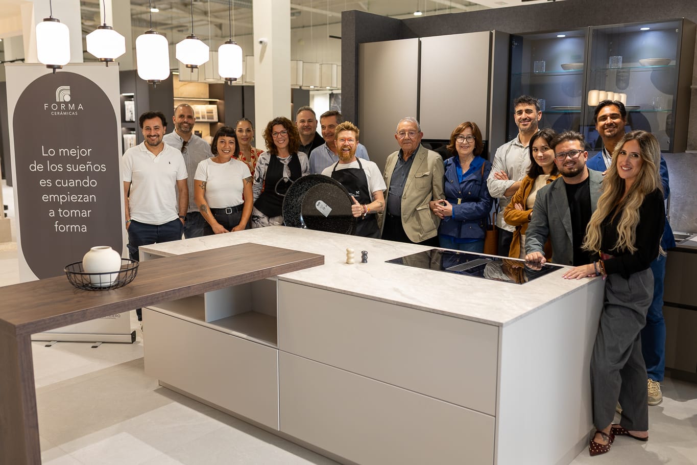Grupo de personas en un evento del showroom junto a una isla de cocina