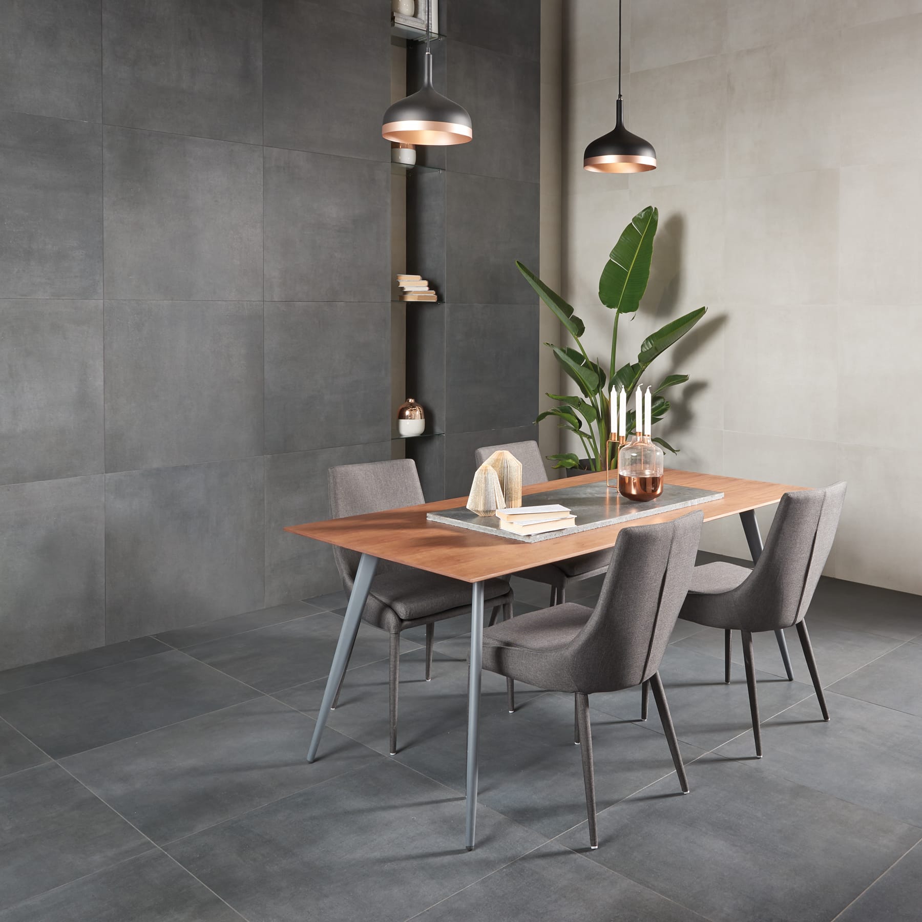 Comedor con pared de azulejo gris oscuro texturizado y lámparas colgantes