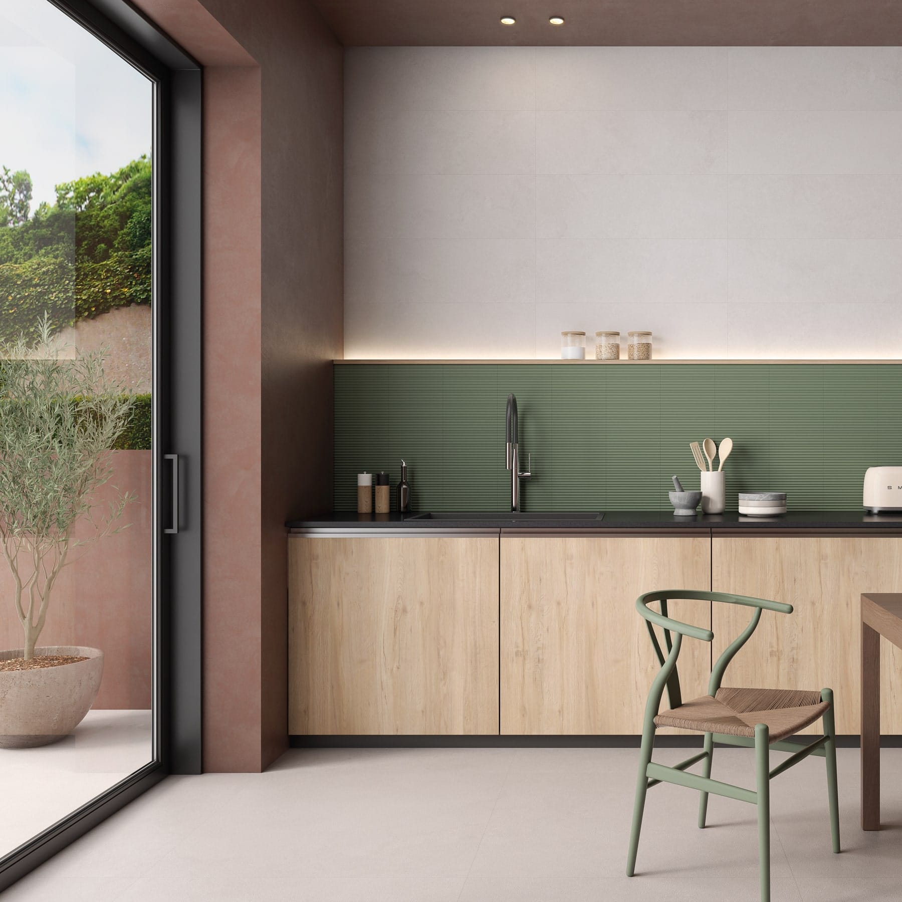 Cocina compacta de madera clara con frente de azulejo verde junto a la terraza