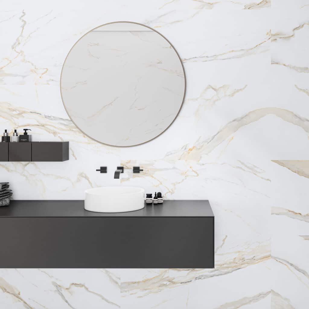 Baño con pared de porcelánico efecto mármol Calacatta y lavabo redondo