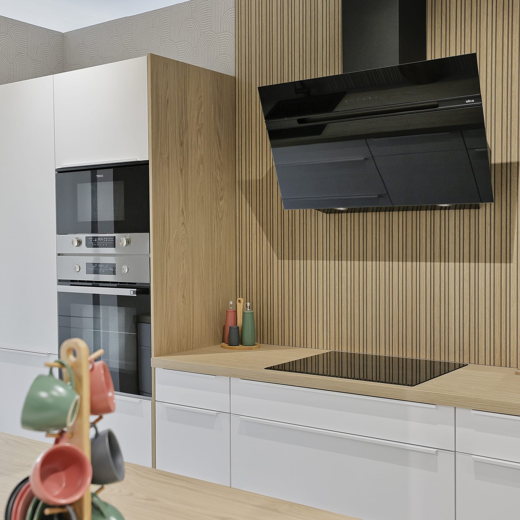 Cocina blanca y madera con campana negra angular y horno doble empotrado