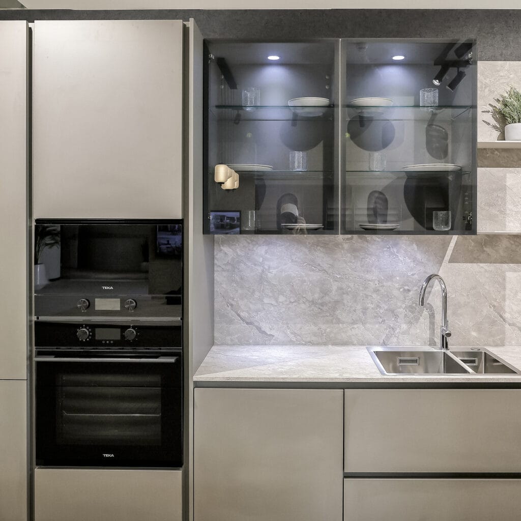 Cocina expuesta en el showroom con columna de horno, vitrinas y fregadero doble