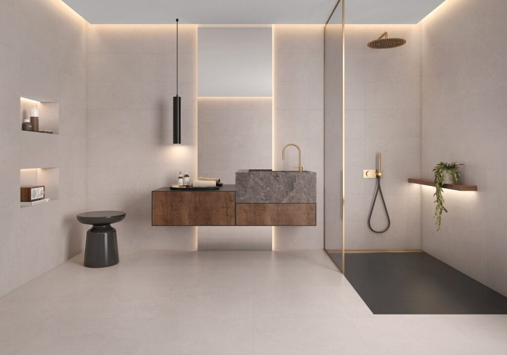 Baño con revestimiento porcelánico beige de gran formato, encimera de mármol y ducha con plato oscuro