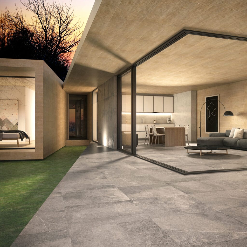 Casa acristalada con el mismo suelo porcelánico gris en salón y porche