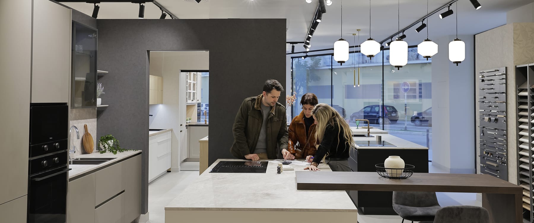 Showroom de cocinas con clientes asesorados junto a una isla